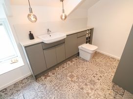A bathroom with patterned floor tiles a sink grey cabinets and a toilet at Anneth Lowen in Angarrack near Hayle