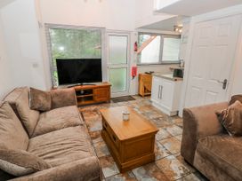 A living room with a television and coffee table at Trelessy Lodge in Llanteg near Amroth