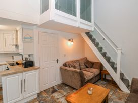 A living room with a sofa and staircase at Trelessy Lodge near Llanteg