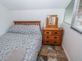 A bedroom with a bed and a bedside table at Trelessy Lodge in Llanteg near Amroth