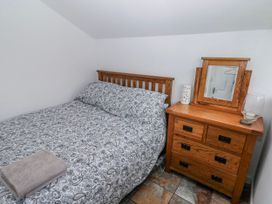 A bedroom with a bed and bedside table at Trelessy Lodge Llanteg near Amroth