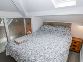 A bedroom with a double bed and nightstand at Trelessy Lodge in Llanteg near Amroth
