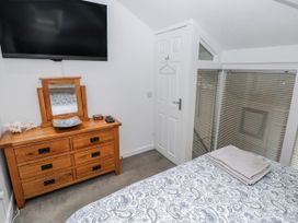A bedroom with a television and dressing table at Trelessy Lodge Llanteg near Amroth