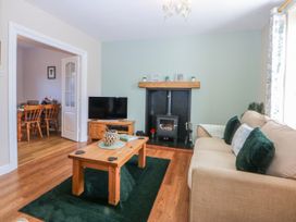 A living room with a sofa, coffee table, and fireplace at Bythynnod Newydd Trefor near Nefyn