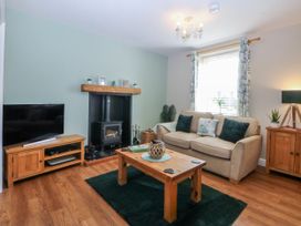 A living room with a television and fireplace at Bythynnod Newydd in Trefor near Nefyn
