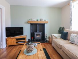 A living room with a television and sofa at Bythynnod Newydd in Trefor near Nefyn