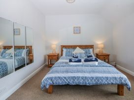 A bedroom with a bed and nightstand at Bythynnod Newydd Trefor near Nefyn
