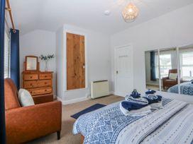 A bedroom with a bed and a dresser at Bythynnod Newydd Trefor near Nefyn