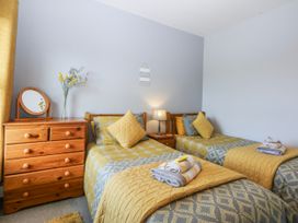A bedroom with twin beds and a dressing table at Bythynnod Newydd Trefor near Nefyn
