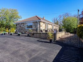 A house with stone exterior and driveway at Blacksmiths Cottage in Shilbottle