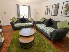 A living room with sofas and a coffee table at Blacksmiths Cottage in Shilbottle