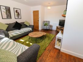 A living room with a sofa and coffee table at Blacksmiths Cottage in Shilbottle