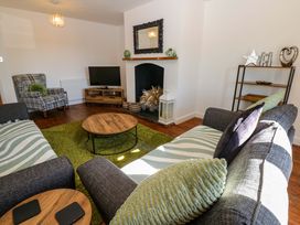 A living room with a coffee table and sofa at Blacksmiths Cottage in Shilbottle