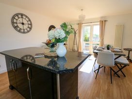A dining room with a kitchen island and a dining table at Blacksmiths Cottage in Shilbottle