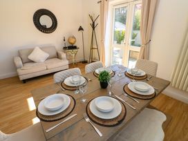 A dining room with a table set for dinner at Blacksmiths Cottage in Shilbottle
