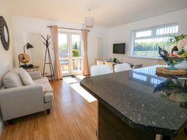 A living room with a sofa and dining area at Blacksmiths Cottage in Shilbottle