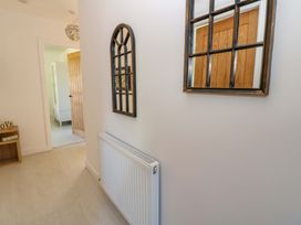 A hallway with a mirror and radiator at Blacksmiths Cottage in Shilbottle