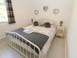 A bedroom with a bed and bedside tables at Blacksmiths Cottage in Shilbottle
