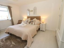 A bedroom with a bed and wardrobe at Blacksmiths Cottage in Shilbottle