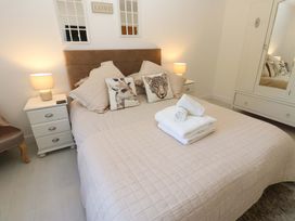 A bedroom with a bed and nightstand at Blacksmiths Cottage in Shilbottle