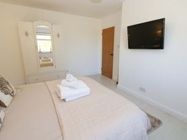 A bedroom with a bed and wardrobe at Blacksmiths Cottage in Shilbottle