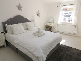 A bedroom with a bed and nightstand at Blacksmiths Cottage in Shilbottle