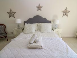 A bedroom with a bed and decorative elements at Blacksmiths Cottage in Shilbottle