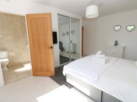 A bedroom with a bed and bathroom door at Blacksmiths Cottage in Shilbottle
