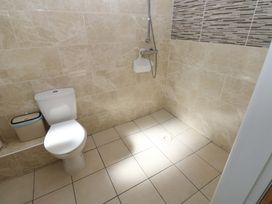 A bathroom with a toilet and shower at Blacksmiths Cottage in Shilbottle