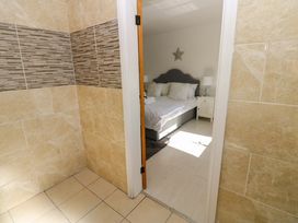 A bedroom view with a bed and nightstand at Blacksmiths Cottage in Shilbottle
