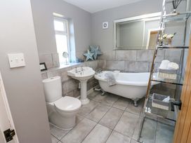 A bathroom with a sink toilet and bath tub at Blacksmiths Cottage in Shilbottle