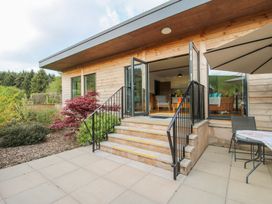 An outdoor patio with stairs leading to an open room with chairs and a table at No1 The Lodge in Acton near Bishops Castle