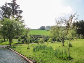 A garden area with trees grass and a gravel path at No1 The Lodge in Acton near Bishops Castle