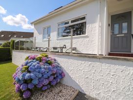 A house exterior with flowers and chairs at Bay View in Benllech