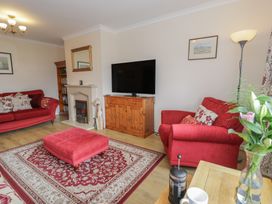 A living room with a television and seating at Bay View in Benllech