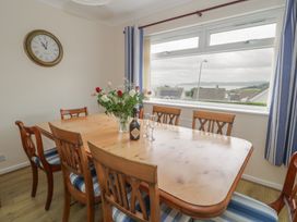 A dining room with a table and chairs at Bay View in Benllech