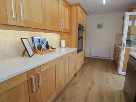 A kitchen with cabinets and countertop at Bay View in Benllech