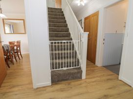 A hallway with a staircase and a dining area at Bay View in Benllech