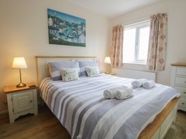 A bedroom with a bed and bedside table at Bay View in Benllech
