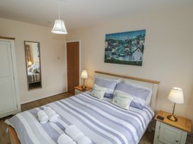 A bedroom with a bed and bedside tables at Bay View in Benllech