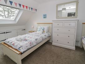 A bedroom with a bed and chest of drawers at Bay View in Benllech