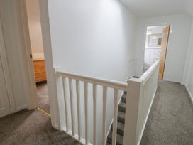 A hallway with a staircase and doors at Bay View in Benllech
