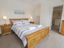 A bedroom with a bed and side tables at Bay View in Benllech