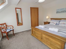 A bedroom with a bed and a chair at Bay View in Benllech