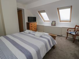 A bedroom with a bed and a TV at Bay View in Benllech