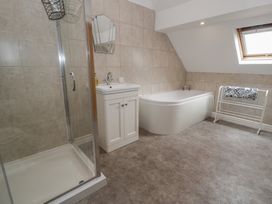 A bathroom with a shower and bathtub at Bay View in Benllech