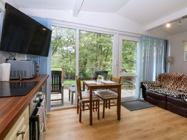 A living room with a dining table and sofa at River's Nook in Llangynog
