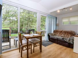 A living room with a dining table and chairs at River's Nook in Llangynog