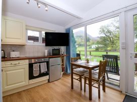 A kitchen with dining table and appliances at River's Nook in Llangynog