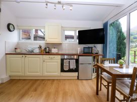A kitchen with cabinets and appliances at River's Nook in Llangynog